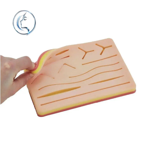 Peach-colored silicone 3-layer suture training pad with yellow and red edges and embossed anatomical patterns for tactile practice